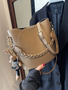 Fashionable khaki pleated bucket bag with a woven handle and a cute rabbit charm