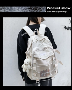 Rear view of a cream-colored casual backpack with elastic rope and bear charm