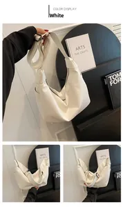 Detail of white moon hobo bag showing the knot handle design and silver metal zipper