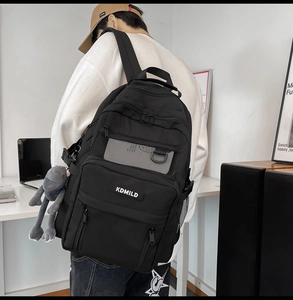 Black multi-layer backpack with mesh pocket and plush frog charm accessory