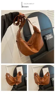 Detail view of large brown leather tote bag with adjustable strap and zip closure