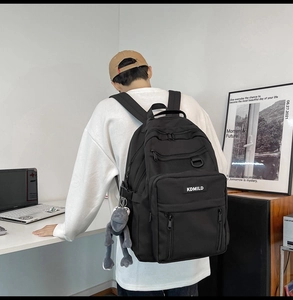 Close-up of black multi-pocket backpack with durable fabric and KDMILD logo detail