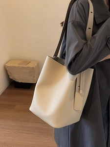 Sac seau minimaliste en cuir crème avec large bandoulière réglable pour femme élégante