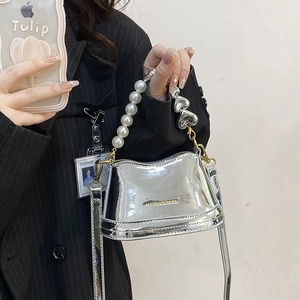 Sac seau argenté brillant avec poignée en perles et breloque cœur, vue de profil