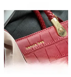 Detail of red tote bag featuring crocodile embossed leather and woven handles