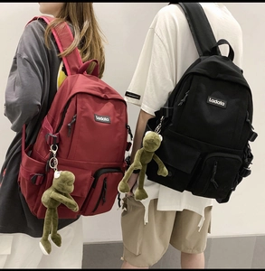 Detail of Korean-style nylon school backpack featuring side pockets and frog keychain