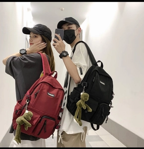 Burgundy and black large capacity fabric backpacks featuring a cute frog plush keychain