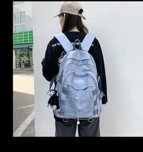 Outdoor view of a light blue-grey backpack with mesh pockets and crisscross rope detailing