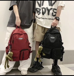 Close-up of durable nylon backpacks in red and black with multi-pocket storage and cute charm