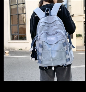 Detailed view of light purple nylon backpack with mesh pockets and decorative crossover ropes