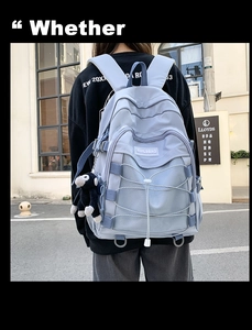Outdoor street style view of a light blue nylon backpack with decorative white elastic cords