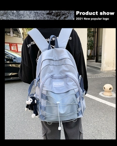 Detailed back view of a light blue casual backpack with mesh pocket and elastic cords