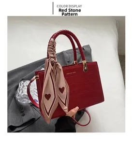 Detailed view of red crocodile textured bridal tote bag with elegant silk scarf on handle