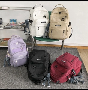 Detailed view of large-capacity multi-layer backpacks in white, beige, purple, black, and red