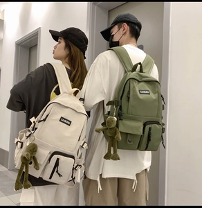 Matching cream and olive green nylon backpacks with Ladata logo and cute frog pendant charms