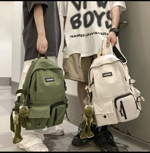 Close-up of dual-pocket waterproof nylon backpack featuring tactical buckles and a frog charm