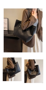 Close-up of black leather tote bag featuring detailed white contrast stitching on straps