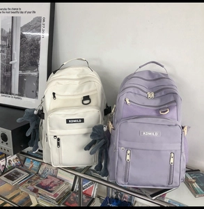 Detail view of large capacity waterproof student backpacks in cream and light purple colors