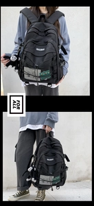 Detail of black multi-functional backpack with logo and cute monkey plush pendant charm