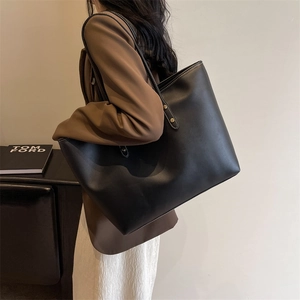 Large capacity black leather tote bag with white contrast stitching and gold rivets detail