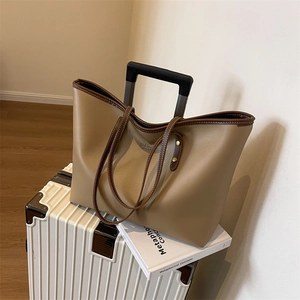Large capacity minimalist tote bag in khaki and brown finish on a white suitcase
