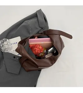 Top-down view of a spacious coffee brown leather tote bag interior holding a tablet and essentials