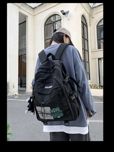 Outdoor view of a black nylon backpack featuring mesh pockets and adjustable buckles