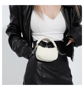 Detail of white half-moon mini handbag featuring a thick handle and silver chain accent