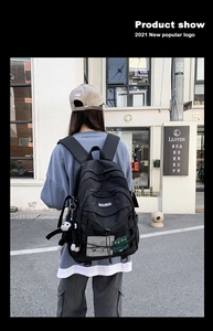 Outdoor shot of a black nylon backpack with mesh side pockets and decorative patches
