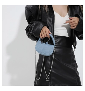 Detail of light blue denim mini handbag with silver chain strap and top handle