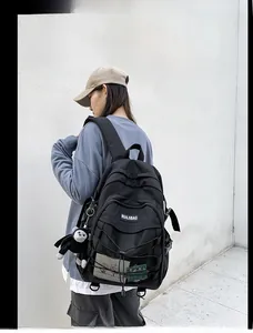Detail of black multi-functional backpack featuring mesh pocket and elastic bungee cords