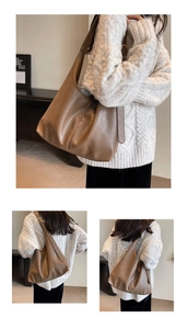 Detail of brown leather tote bag showing textured surface and adjustable wide shoulder strap