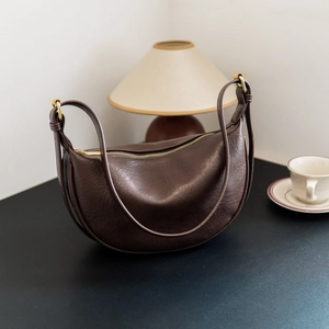Dark brown leather crescent bag for women with minimalist design and gold zipper