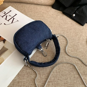Minimalist denim half-moon crossbody bag with silver chain strap and top handle