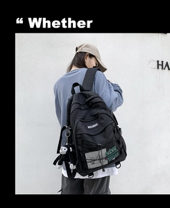 Detail of black backpack featuring cross-rope design, mesh pocket, and cute monkey charm