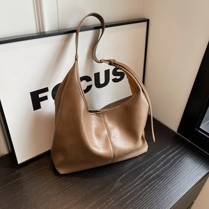 Retro coffee brown PU leather hobo bag with adjustable shoulder strap on wooden table