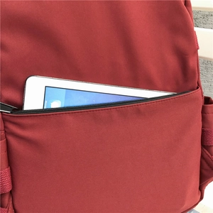 Minimalist burgundy student backpack featuring a spacious side zipper pocket for tablet storage