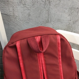 Deep red Korean style student backpack featuring durable top handle and reinforced straps