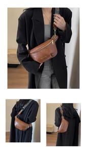 Close-up of brown leather crossbody bag with ethnic embroidered wide strap and gold hardware