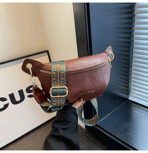 Detail of vintage brown PU leather waist bag with colorful ethnic printed strap