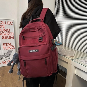 Large capacity red multipurpose nylon backpack with multi-layer pockets and plush charm