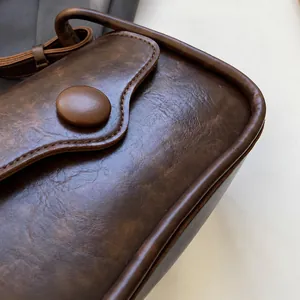 Macro shot of dark brown faux leather bag showing retro texture and fabric-covered button