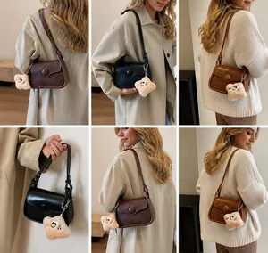 Detailed views of vintage crossbody bag in black and brown with star charm accessory