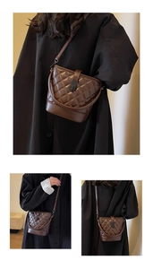 Close-up of brown quilted bucket bag with matte leather finish and metal turn-lock