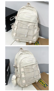 Detail of beige nylon backpack with cross rope mesh pocket and cute bear charm pendant