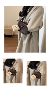 Detail of vintage dark brown crossbody bag with a star plush charm and matte finish