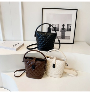 Three elegant quilted bucket bags in black, brown, and cream displayed on white platforms