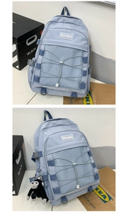Detail of light blue backpack featuring mesh pocket, elastic ropes and plush charm