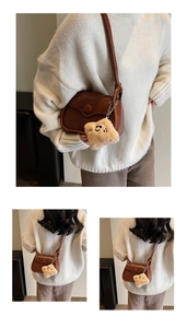 Brown leather crossbody bag detail featuring a cute yellow plush smile pendant accessory