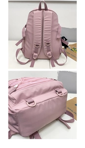 Detailed back view of pink nylon school backpack with mesh pocket and ape pendant